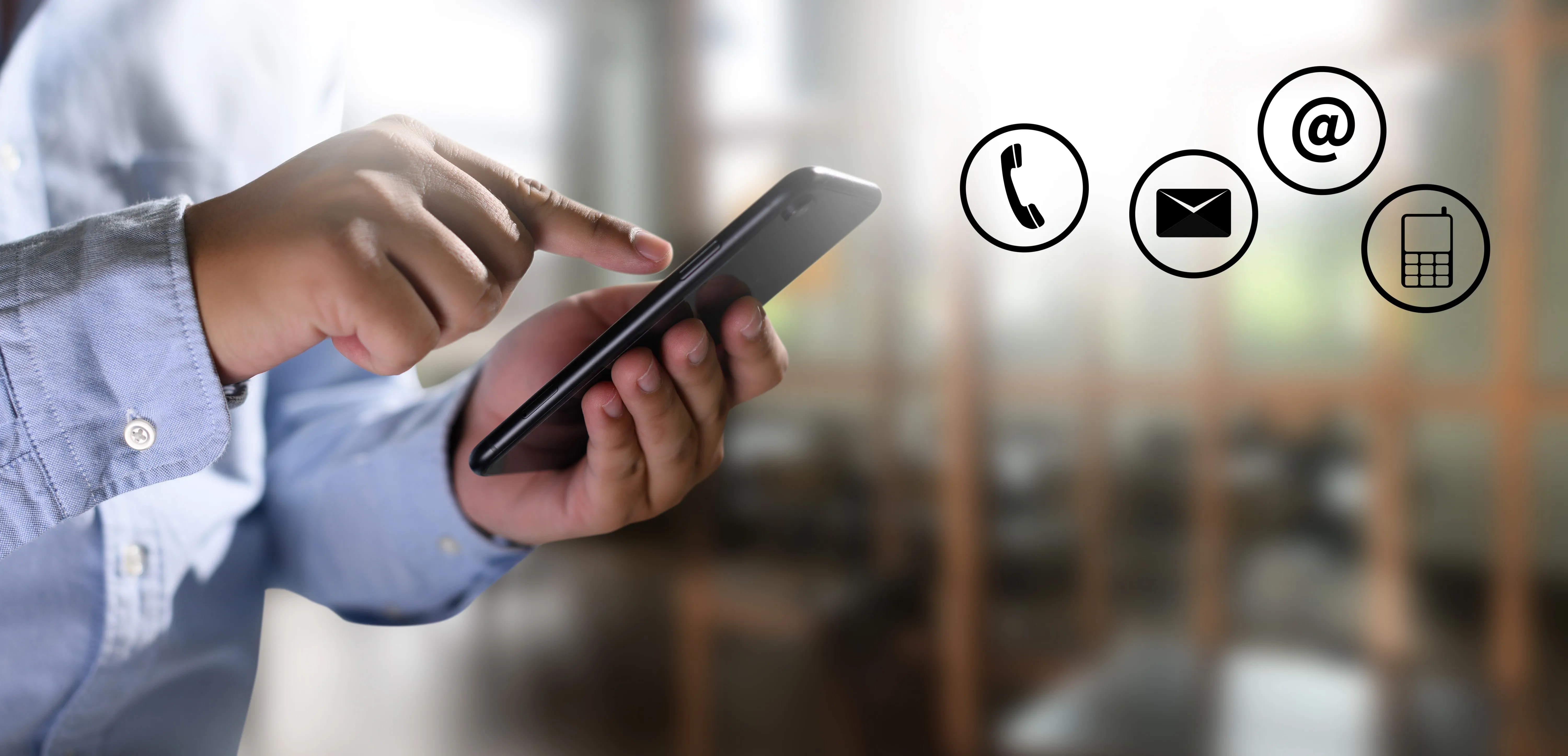 A person holding a mobile phone, with phone, email and message icons shown alongside.